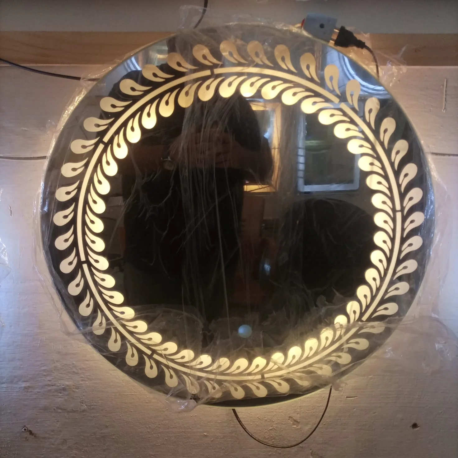 Handcrafted laurel leaf wreath frosted border LED mirror with warm ambient lighting